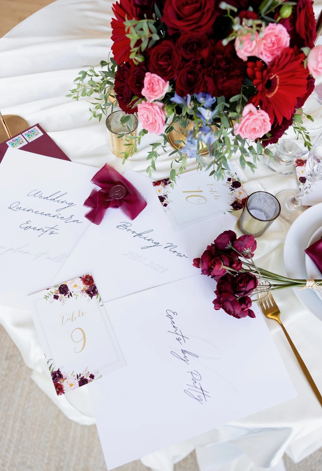 Wedding and quinceañera stationery with burgundy ribbon, table numbers and red florals