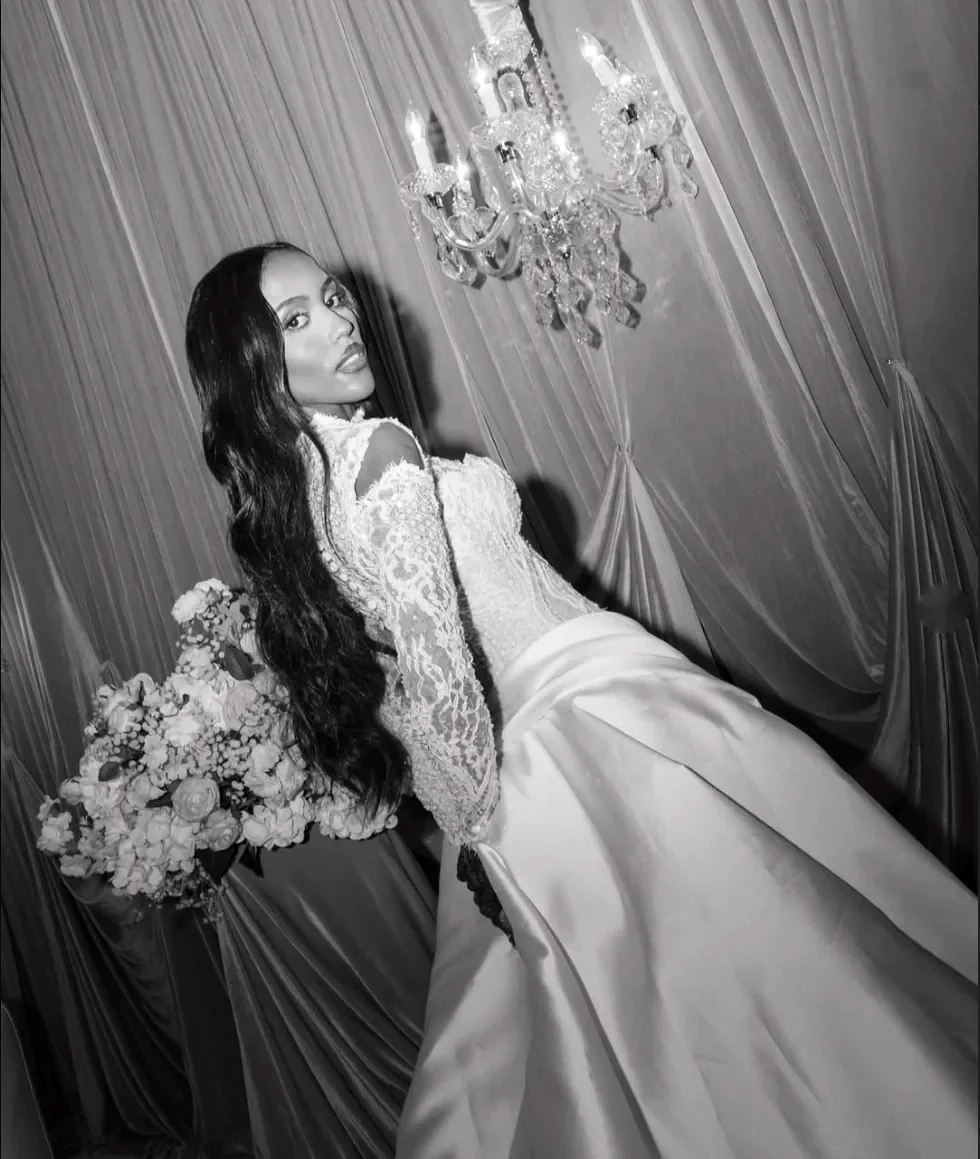 Bride in black and white beneath a crystal chandelier